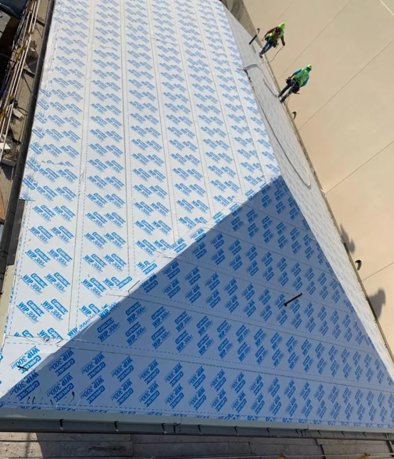 Professional roofers installing underlayment on a metal roof in Galliano